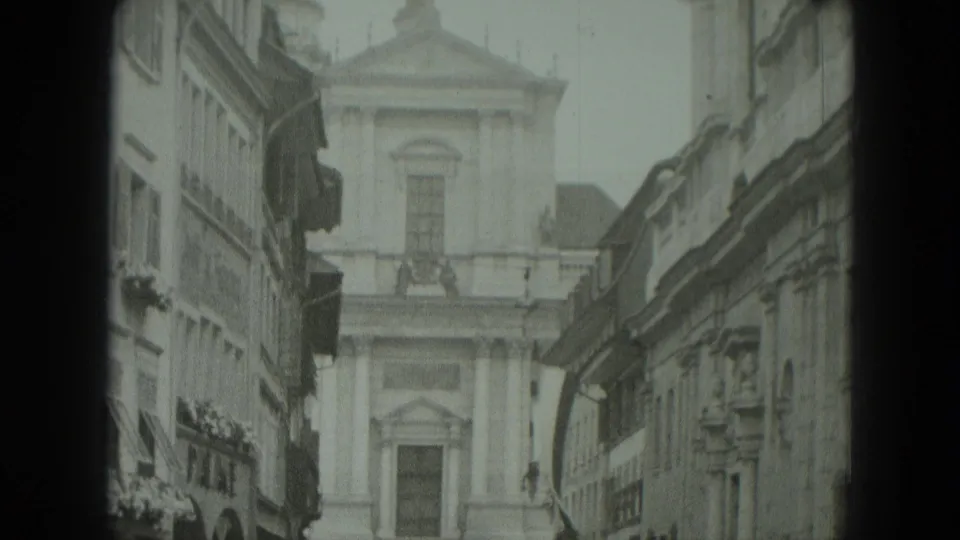 West Germany 8mm frame showing a church at the end of a narrow street bordered by historic building facades.