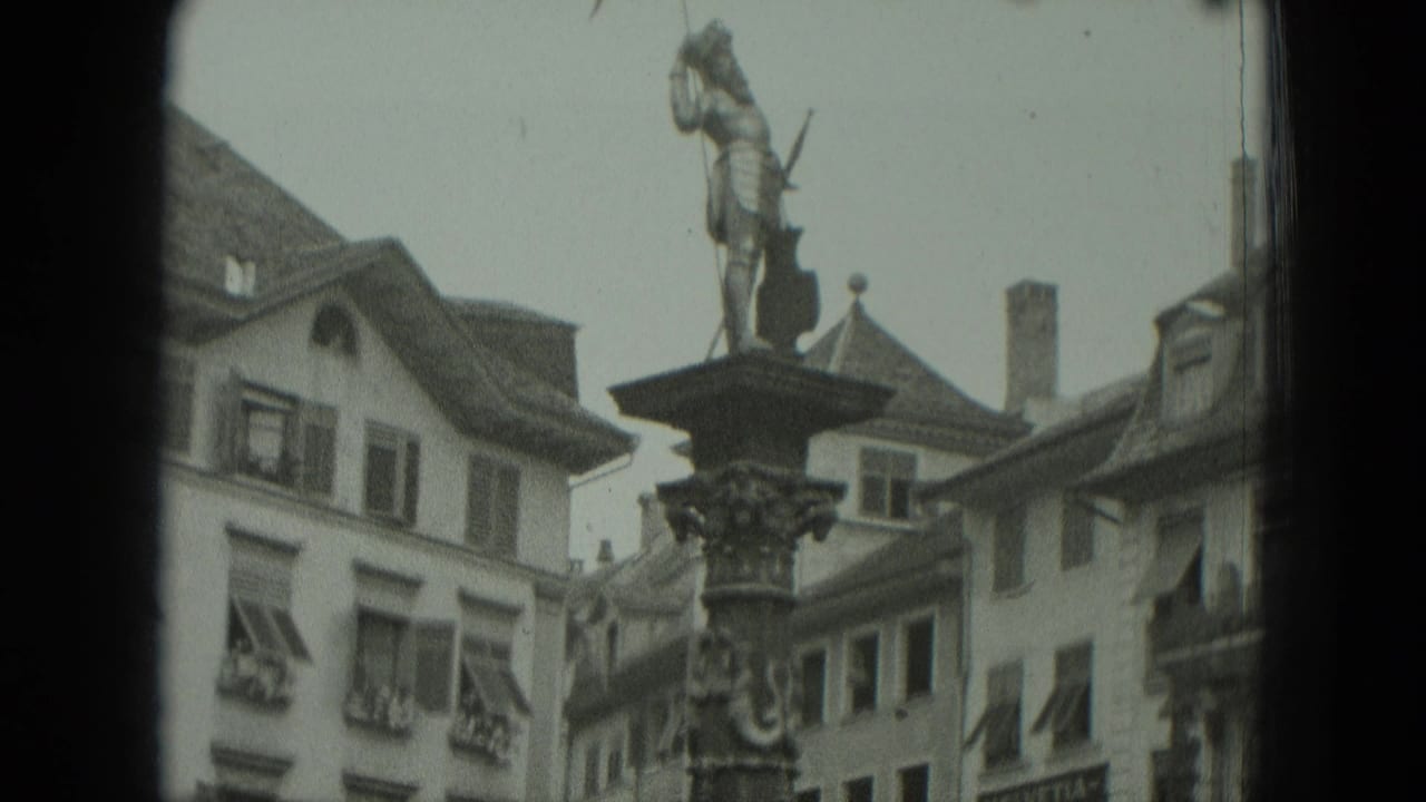 Historic statue on an ornate column above shuttered town buildings.