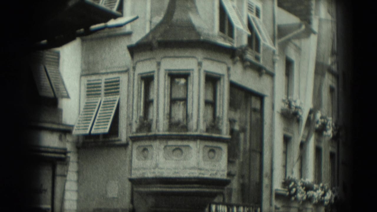1951 Germany 8mm frame showing an older urban building facade with a projecting bay window, louvered shutters, and flower boxes.