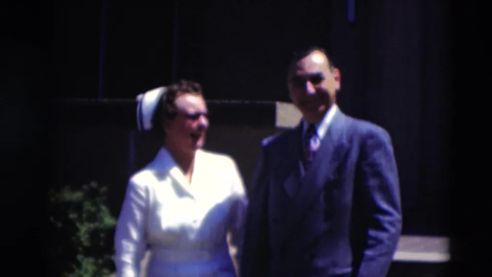 In 1951 Paducah, Kentucky, a woman in a white uniform and cap stands with a suited man outside a shaded building.