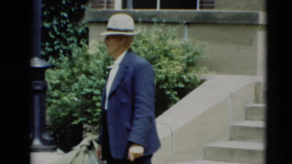 The man in a light fedora appears in profile near stone steps and greenery in the Paducah, Kentucky home movie.
