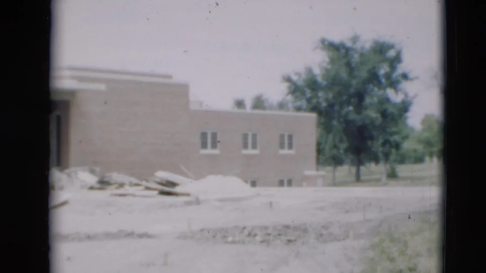 A brief exterior view shows a low brick building, scattered materials, trees, and open ground in Paducah, Kentucky footage.