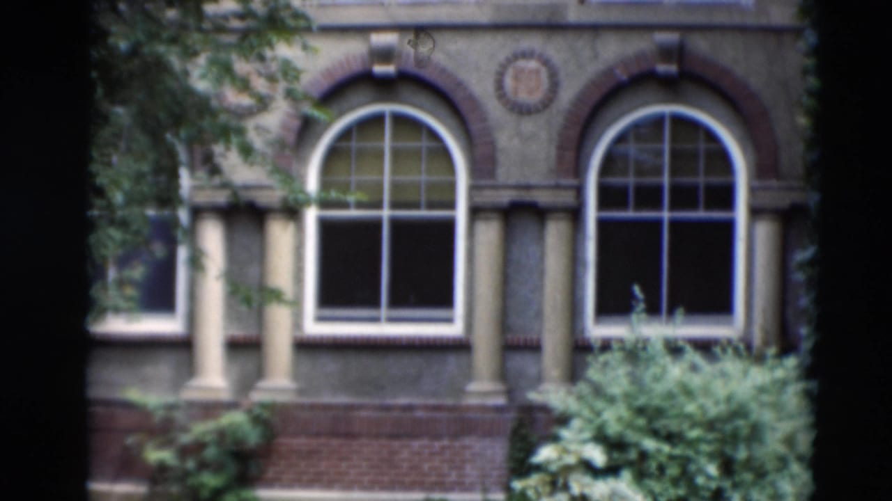 Paducah, Kentucky building exterior with arched windows, decorative brickwork, ivy, pale columns, and planted greenery.
