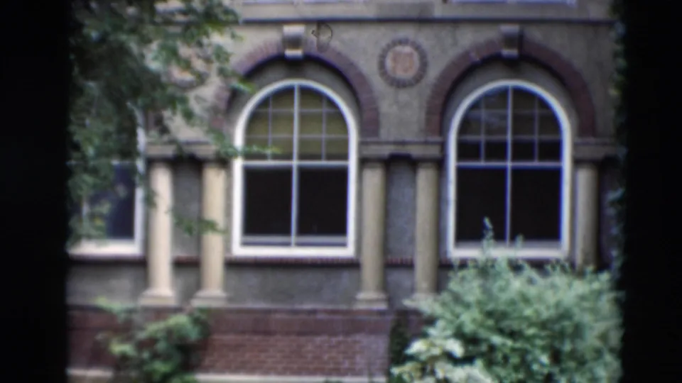 Paducah, Kentucky building exterior with arched windows, decorative brickwork, ivy, pale columns, and planted greenery.