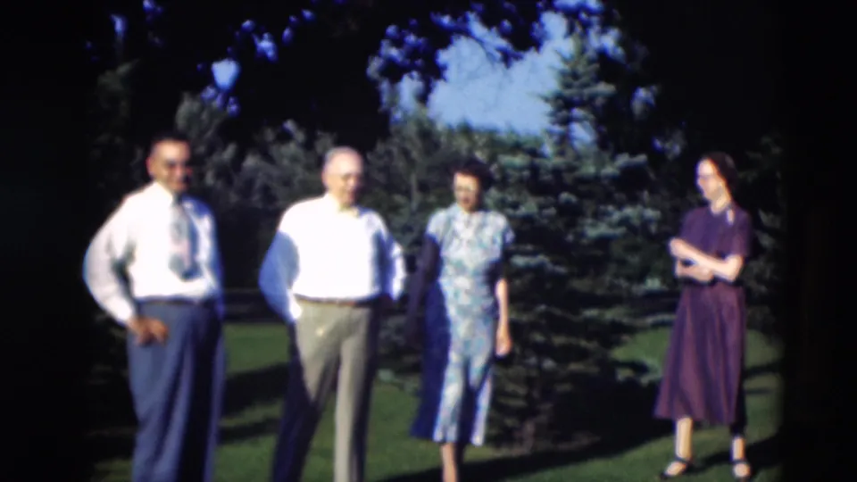 Men in dress shirts and a woman in a patterned dress stand outdoors in Paducah, Kentucky, in 1951 home-movie footage.