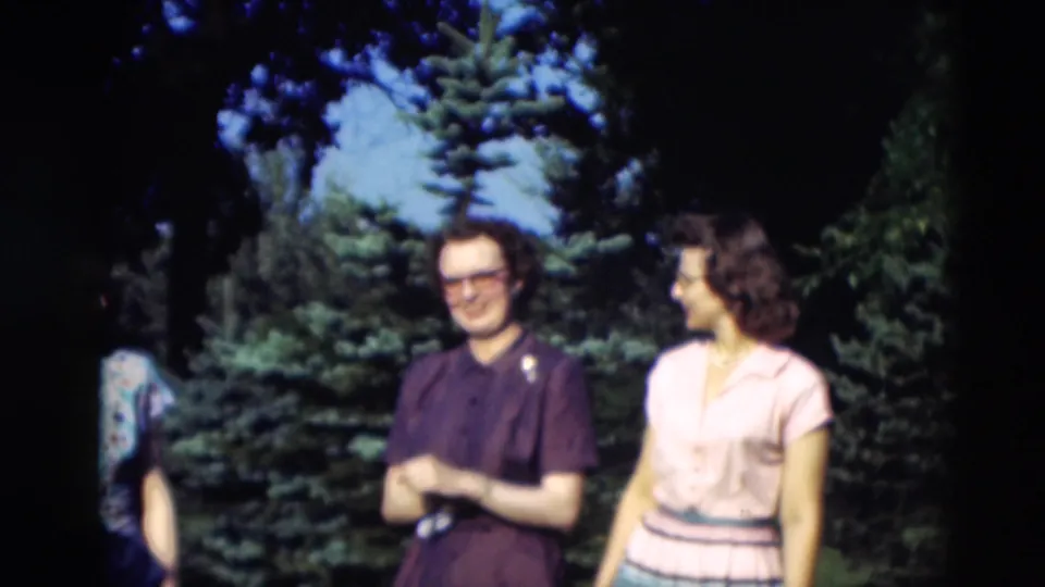 A man in a dark shirt and a woman in a pale blouse appear to smile and converse outdoors in 1951 Paducah home-movie footage.