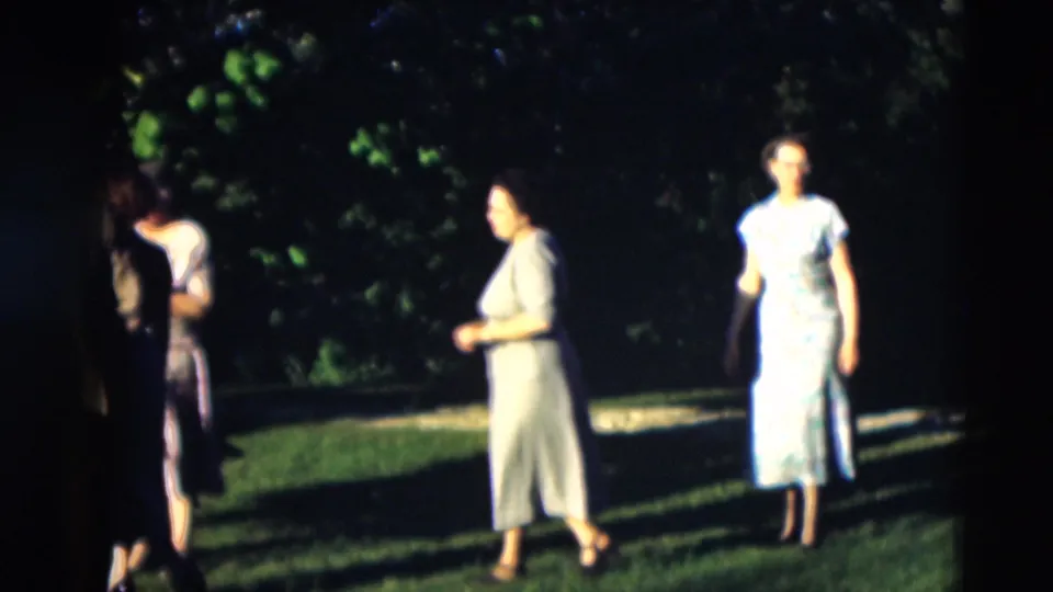 Women in mid-century dresses walk across a green lawn in 1951 Paducah, Kentucky home-movie footage.