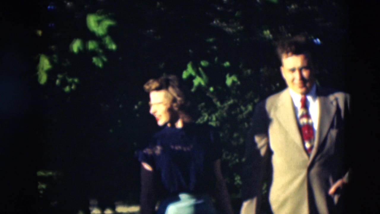 1951 Paducah garden scene with a smiling woman in a dark top beside a man in a light suit, both partly softened by motion and exposure.