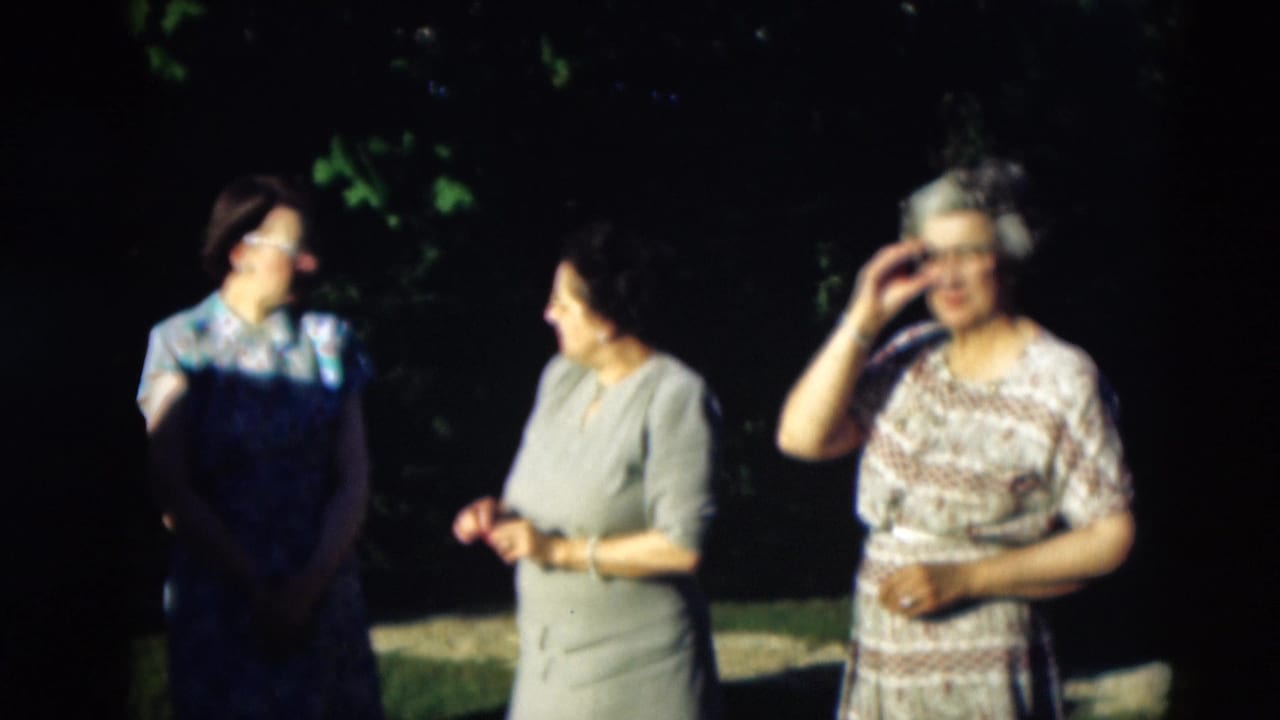 1951 Paducah outdoor frame with three women in mid-century dresses, one adjusting her glasses as the others face her.