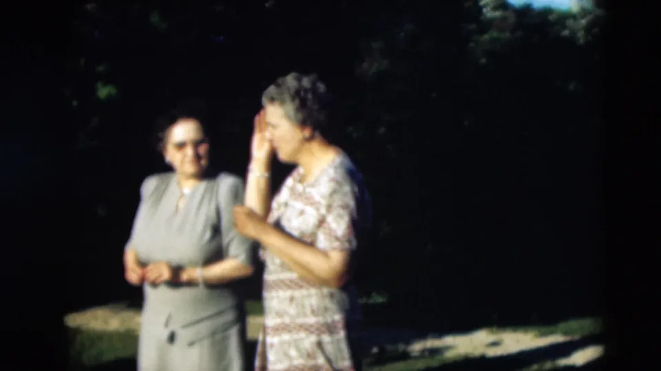 1951 Paducah frame showing two women in dress clothing outdoors, with one smiling toward camera and another turned in profile.