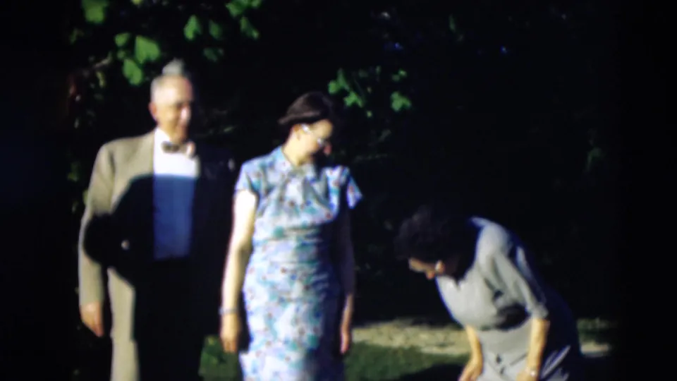 A man in a suit and two women in dresses appear in a shaded outdoor gathering in 1951 Paducah, Kentucky home-movie footage.