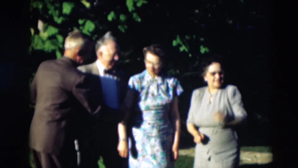 Older adults in suits and dresses cluster under leafy shade during a 1951 Paducah, Kentucky outdoor social gathering.