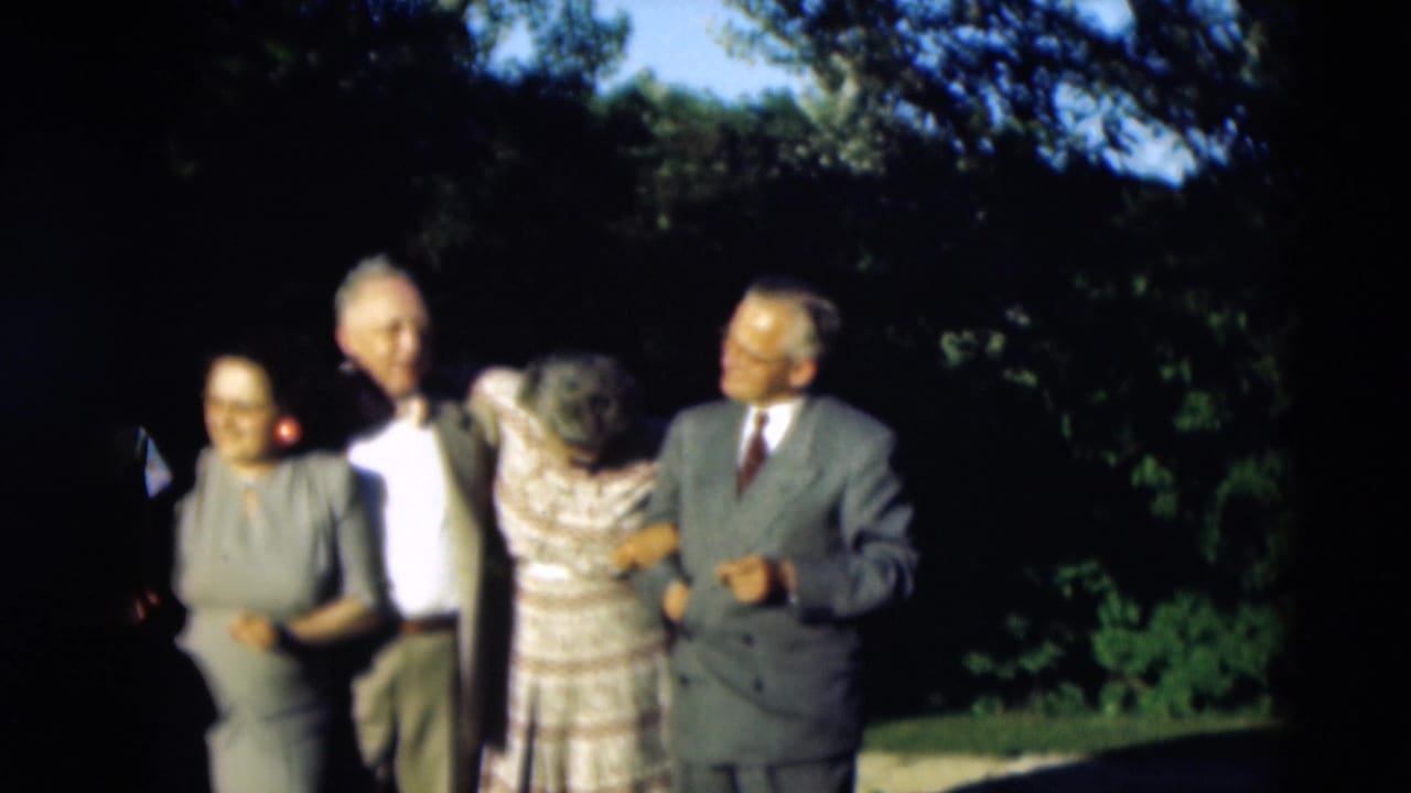 A 1951 Paducah, Kentucky home-movie frame shows adults in suits and dresses gathering outdoors for a posed group photo.