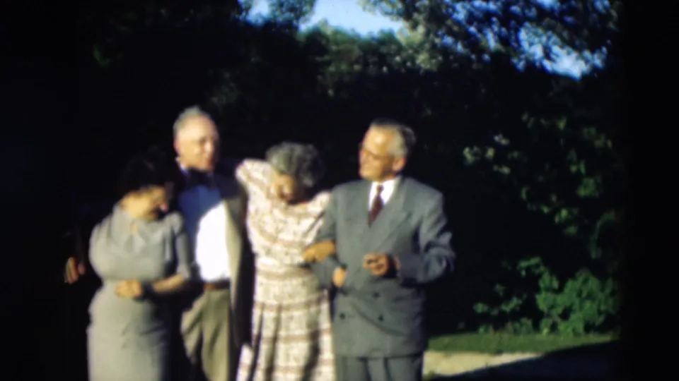 Adults in mid-century formal clothing stand close together in Paducah, Kentucky, appearing to prepare for a group portrait.