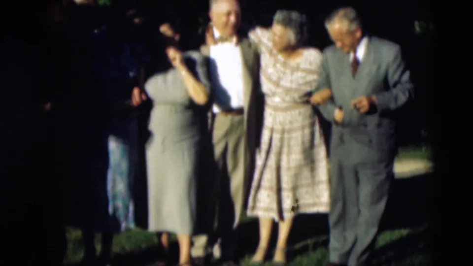 Older adults in formal clothing stand arm in arm in a 1951 Paducah family gathering, with trees and lawn behind them.