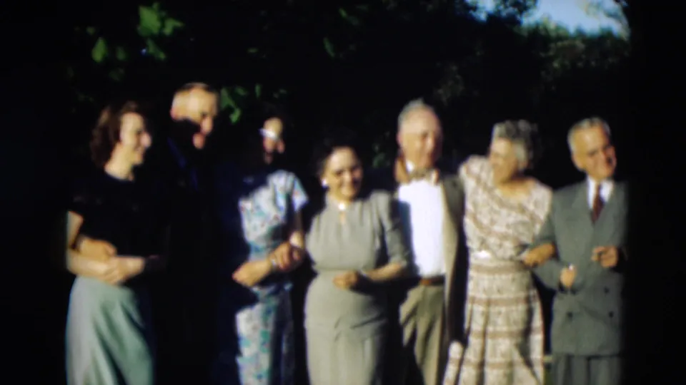A wider 1951 Paducah home-movie frame shows adults joining the outdoor group portrait under tree shade.