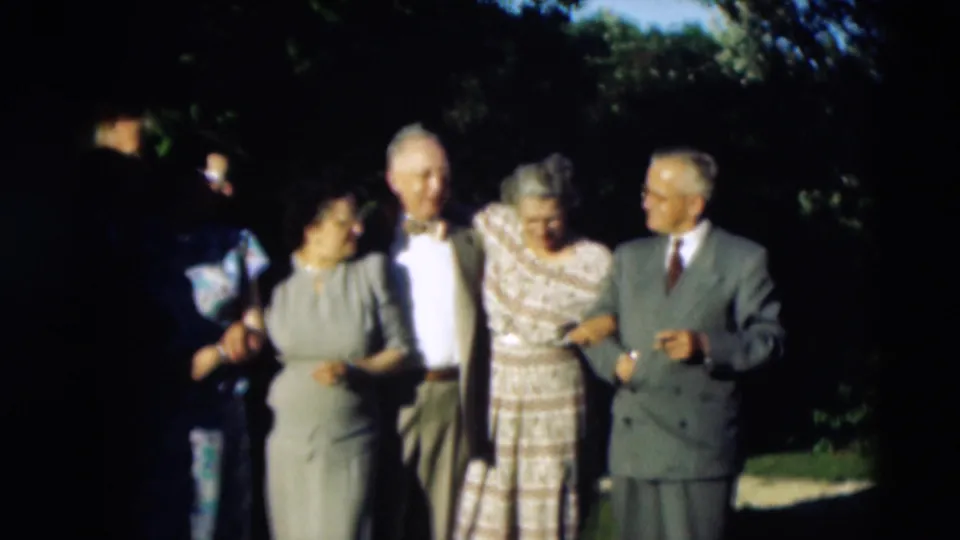Adults in dresses and suits continue posing together on a lawn in the 1951 Paducah home-movie footage.