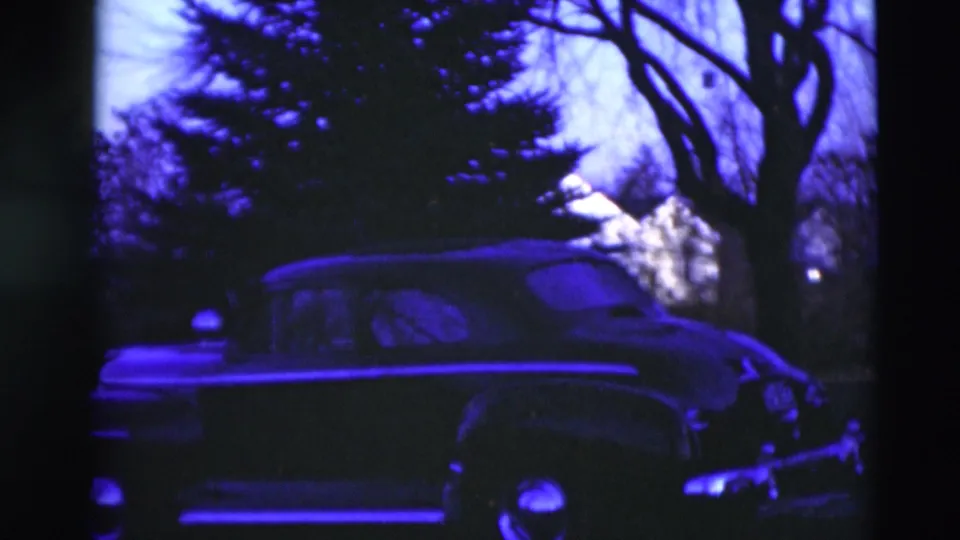 At the end of the 1951 Paducah pan, the car, trees, yard, and light-colored house remain visible in soft blue-purple 8mm footage.
