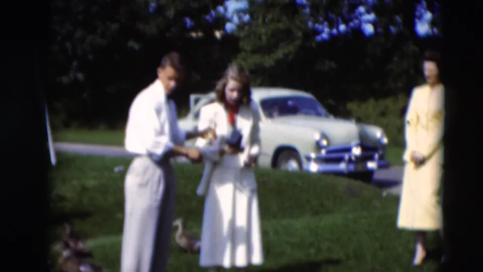 Adults in dress clothing stand on a Paducah lawn in 1951, with a pale mid-century sedan visible in the background.