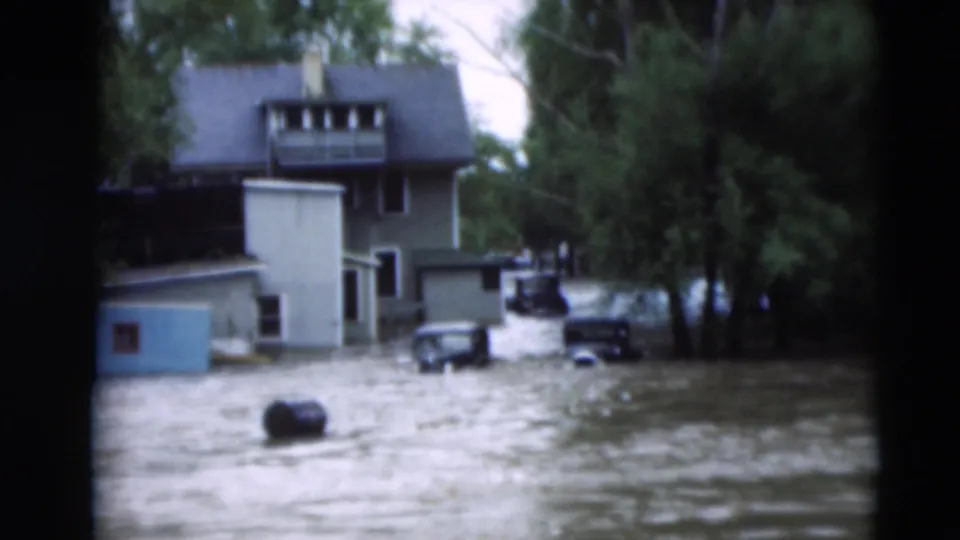 Flooded street near a house and vehicles in the 1951 Paducah, Kentucky home-movie footage, seen in soft 8mm color.