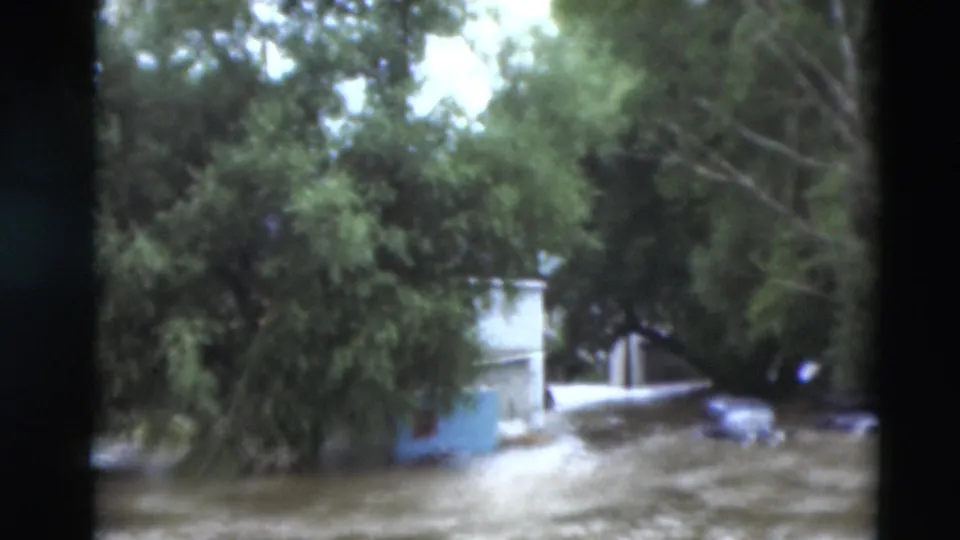A Paducah residential area appears inundated, with water around houses and trees in grainy 8mm footage from 1951.