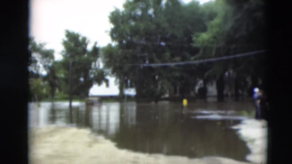 The 1951 Paducah flood scene shows people near a dry edge, with water covering the street under trees and utility lines.
