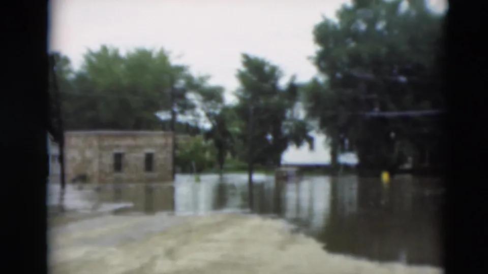 1951 Paducah, Kentucky frame showing a small masonry-looking building partly surrounded by floodwater in a residential neighborhood.
