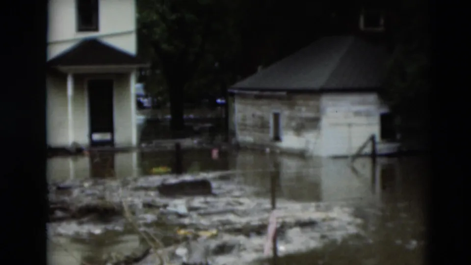 1951 Paducah flood footage shows muddy water and debris around residential buildings and trees.