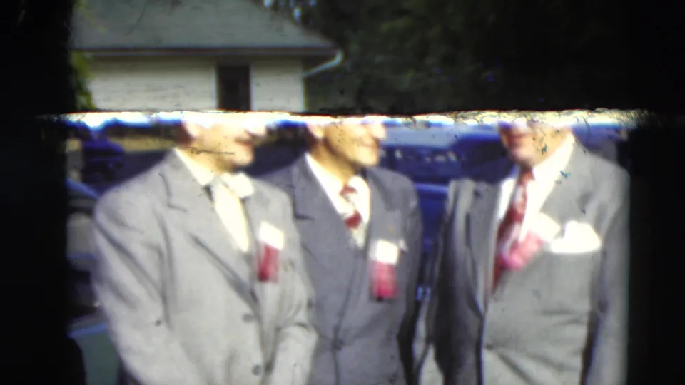 The clip ends on suited men with ribbon badges, likely adults at a local gathering or response scene in the 1951 Paducah material.