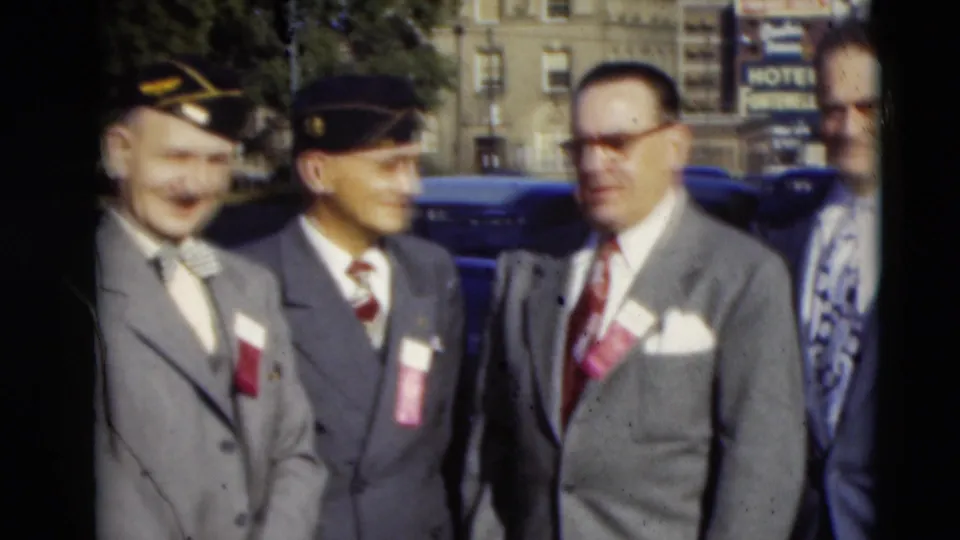 In 1951 Paducah, Kentucky, four formally dressed men with caps, ties, and badges stand together on a downtown street.