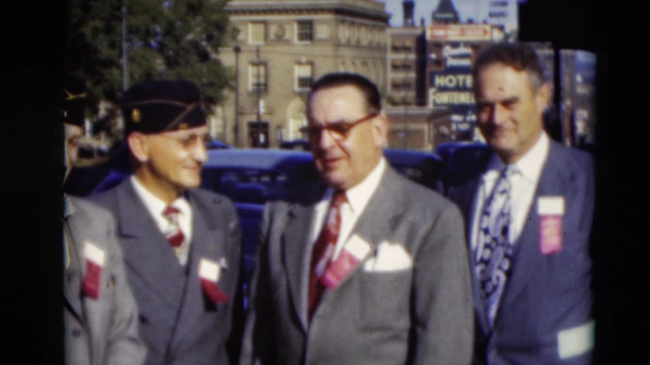 Three men in suits, caps, ties, and badges stand on a Paducah street, with parked cars and a hotel sign behind them.
