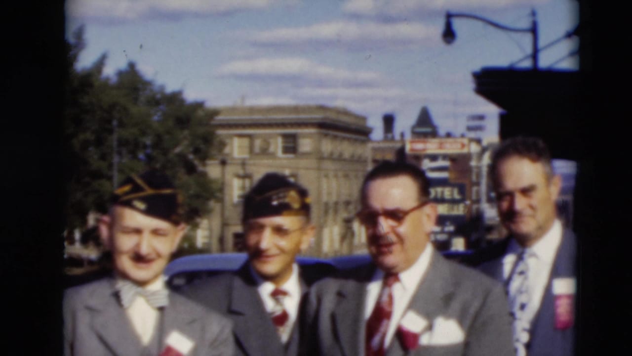 Five adult men in suits, two wearing dark caps, stand outdoors in Paducah, Kentucky, in 1951 with a hotel sign and masonry building behind them.