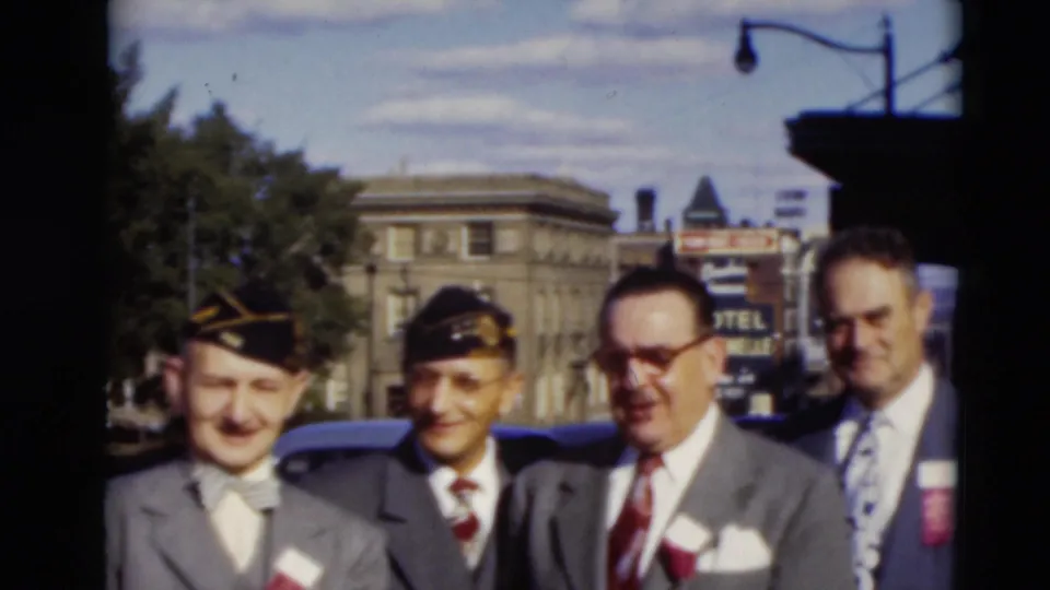 Five adult men in suits, two wearing dark caps, stand outdoors in Paducah, Kentucky, in 1951 with a hotel sign and masonry building behind them.