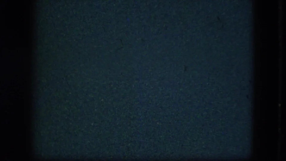 Underexposed 8mm frame from the 1951 Cleveland Christmas-gift clip, with only dark film texture visible.