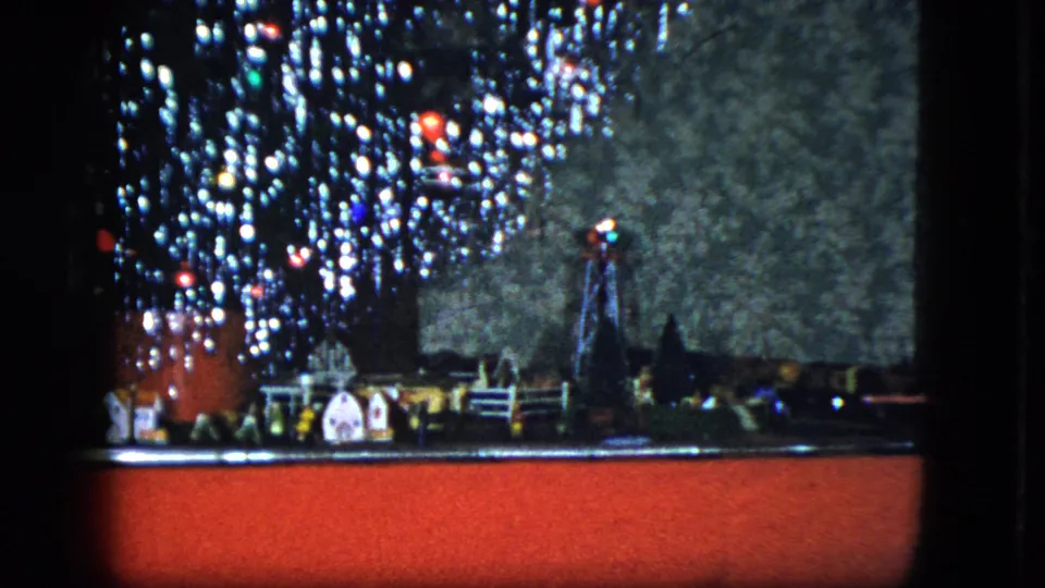 1951 Cleveland frame showing the Christmas tree base with tinsel, ornaments, miniature buildings, and train-track display.