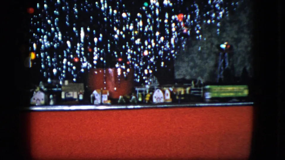 1951 Cleveland frame with a model train scene, toy buildings, and dense holiday lights above a red base.