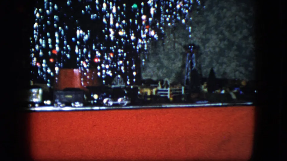 Final 1951 Cleveland frame of the holiday model railroad display beneath bright, soft Christmas tree lights.