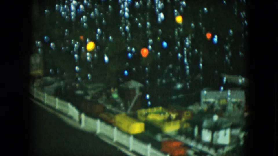 1951 Cleveland home-movie frame showing a decorated Christmas tree near the model train layout and miniature town.