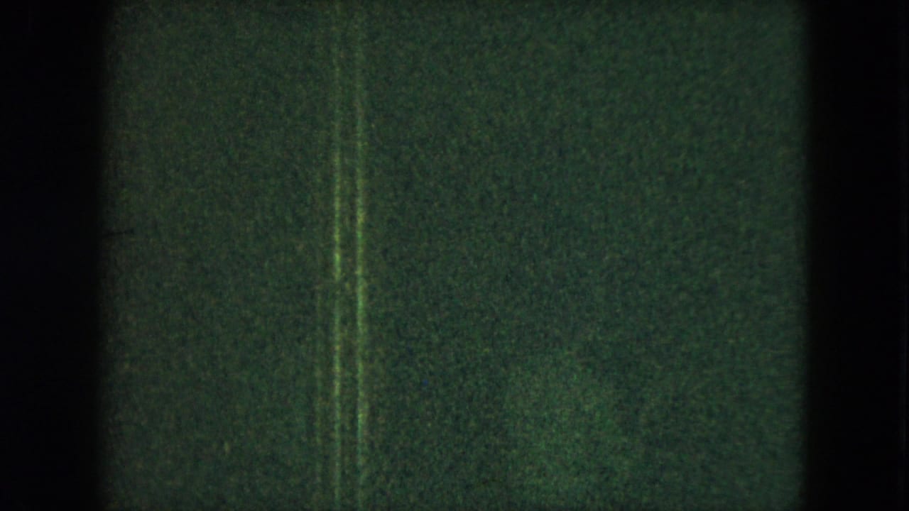 Dark green-tinted frame with vertical film edges and faint interior shapes.