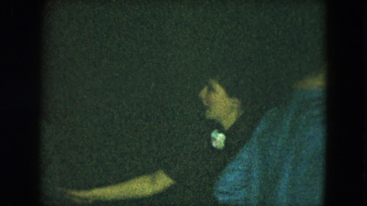 Green-tinted 1951 Cleveland home-movie frame showing adults social dancing in a dim interior.