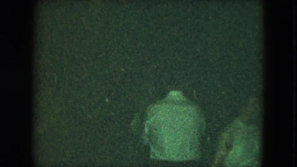 Green-tinted 8mm frame showing adults from behind amid a Cleveland social dance scene.