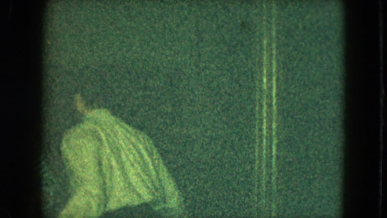 A small figure in a striped sweater appears in a dark 1951 Cleveland home-movie frame with heavy grain and vertical artifacts.