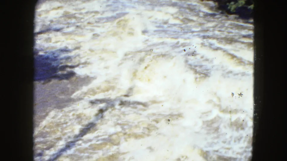 Foaming rapid water appears in a grainy 1951 Cleveland 8mm frame, with bright highlights and visible film wear.