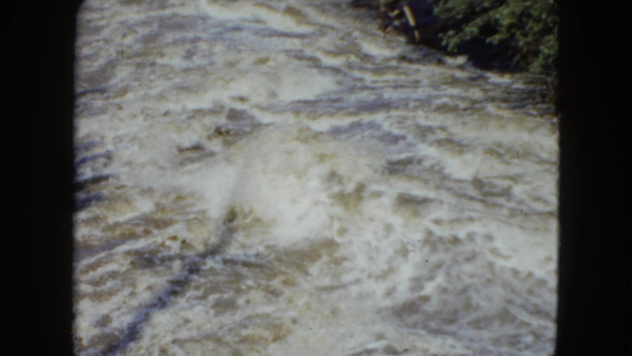 The 8mm frame shows turbulent whitewater near a leafy bank, consistent with the Cleveland, Ohio 1951 clip metadata.