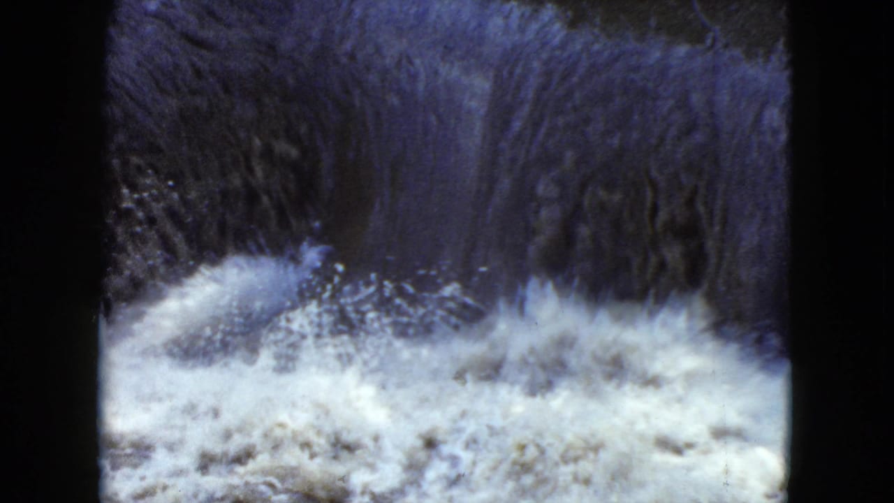 1951 8mm home-movie frame from Cleveland, Ohio showing a small waterfall feeding turbulent white water.