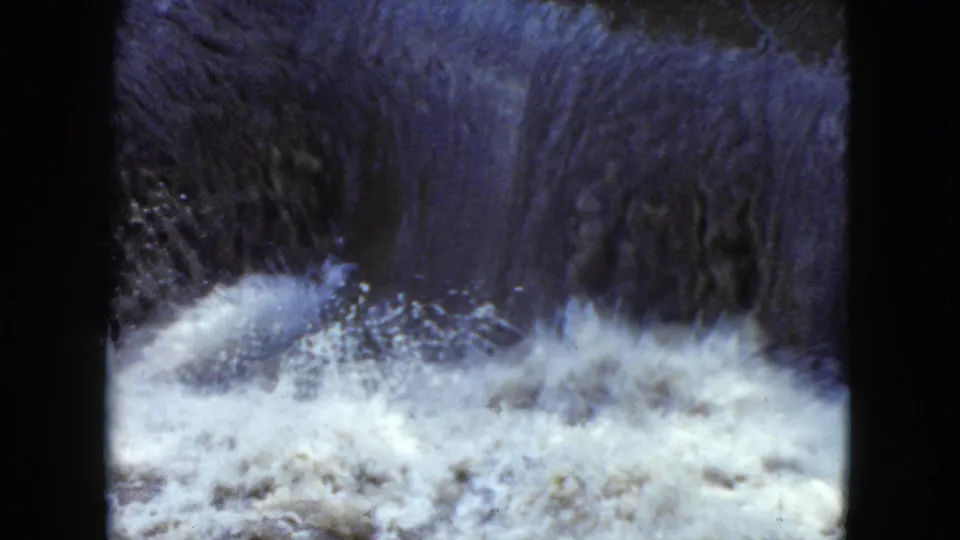 1951 8mm home-movie frame from Cleveland, Ohio showing a small waterfall feeding turbulent white water.