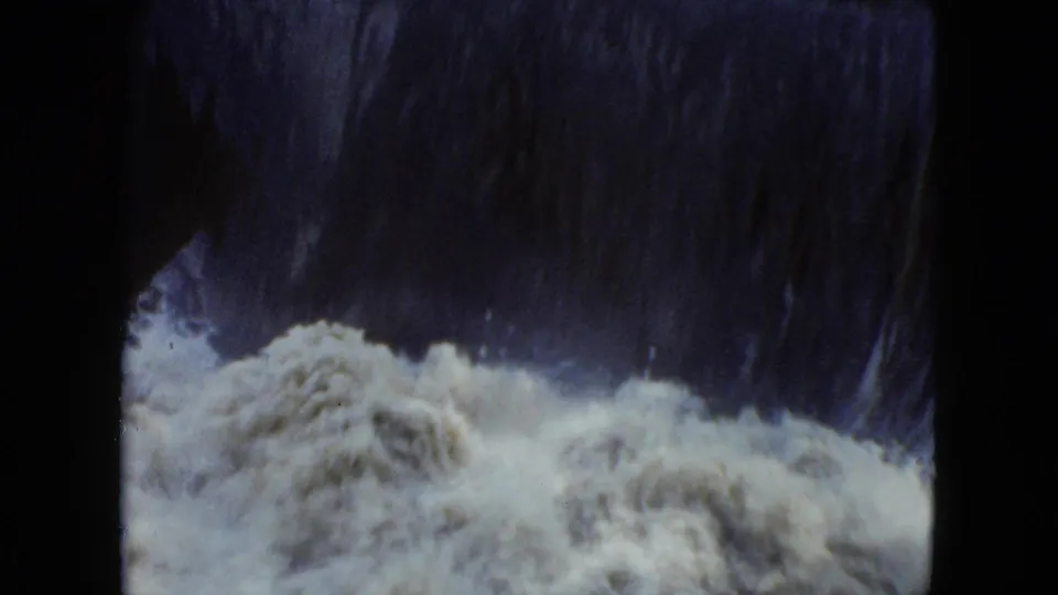 1951 Cleveland-area 8mm frame showing a shadowed waterfall face with pale foam gathering at the base.