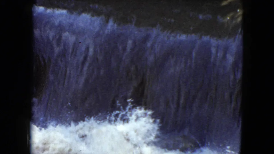 Final 1951 8mm frame from Cleveland, Ohio with white splash rising against a dark blue-gray waterfall face.