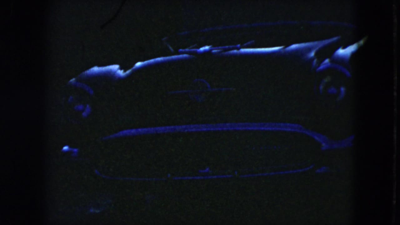 Low-exposure 1951 Cleveland frame showing the side of a parked 1950s car, with blue light catching the roofline, side panel, and trim.