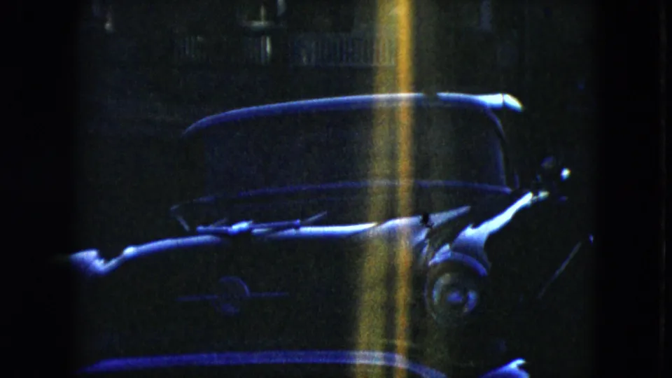 Final 1951 Cleveland frame showing the parked sedan in darkness with a yellow-blue vertical light streak over the body.